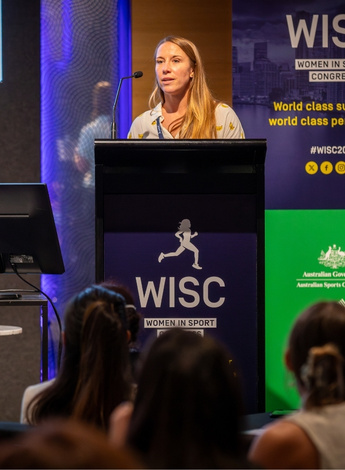 The image is of Stella Veith giving her presentation at the Women in Sport Congress. 